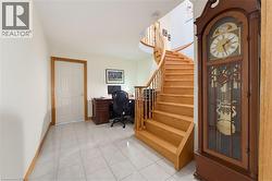 Curved wood staircase featuring wood balusters and a wood handrail - 
