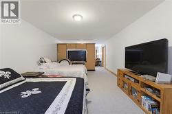 Spacious room featuring light-toned carpet, white walls, and an overhead flush-mount light fixture - 
