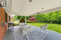 Expansive covered deck featuring recessed lighting, a ceiling fan, and a large open lawn beyond - 