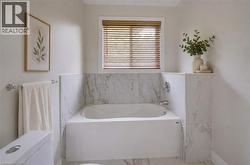Built-in soaking tub with a white surround and polished chrome fixtures - 