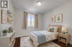 Bedroom featuring rich wood-finish flooring, a double-paned window, and a flush-mount ceiling light - 