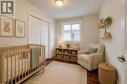 Room featuring wood-finish flooring, a double-door closet with paneling, a single window, and a flush-mount ceiling light - 