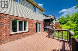 Multi-level rear deck with wood-finish flooring and black metal balusters - 