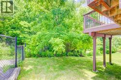 Expansive grassy yard area with mature trees and natural landscaping - 
