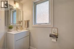 Bathroom featuring a white vanity with integrated sink, brushed nickel faucet, and a large framed mirror - 