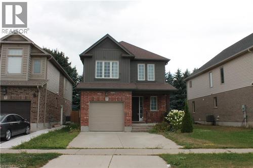 Two-story residence featuring a brick and siding facade, an attached garage, and a concrete driveway - 27 Stillwater Street, Kitchener, ON 