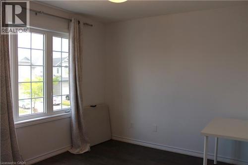 Large window featuring a grid pattern, white framing, and dark wood-finish flooring - 27 Stillwater Street, Kitchener, ON 