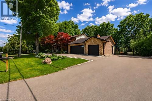 Stone façade garage with a two-car capacity and black garage doors - 355 Edgehill Drive, Kitchener, ON 