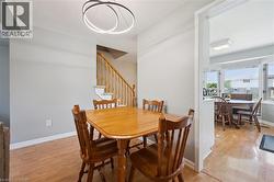 Dining area with wood-finish flooring and a contemporary circular chandelier - 