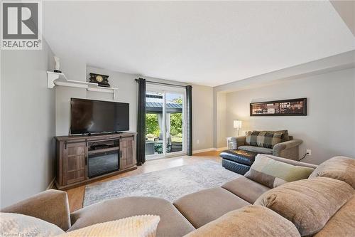 Spacious living area featuring wood-finish flooring, a neutral color palette, and sliding glass doors providing outdoor access - 315 Mayview Crescent Unit# B, Waterloo, ON 