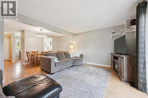 Spacious living area featuring light wood-finish flooring, light gray wall tones, and a large window with vertical blinds - 315 Mayview Crescent Unit# B, Waterloo, ON 