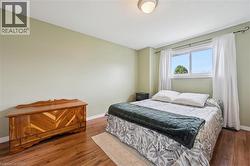 Room featuring light green wall paint and wood-finish flooring - 