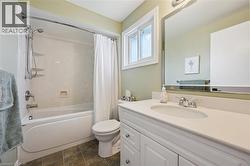Bathroom featuring a white vanity with a light-colored countertop, an undermount sink, and chrome fixtures - 