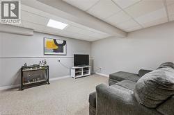 Carpeted room with light grey walls and a drop ceiling featuring recessed lighting - 