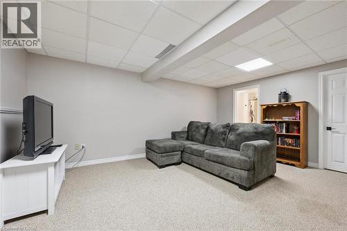 Carpeted lower-level room featuring light gray walls, white trim, and a drop ceiling with recessed lighting - 315 Mayview Crescent Unit# B, Waterloo, ON 