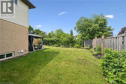 Expansive backyard featuring a manicured lawn, a gazebo with privacy curtains, and established perimeter landscaping - 315 Mayview Crescent Unit# B, Waterloo, ON 