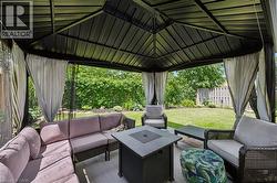 Black metal gazebo featuring a solid roof, privacy curtains, and mesh screens - 
