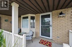 Inviting front porch featuring a brick facade, white railing, and an architectural bay window - 