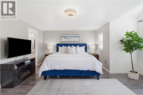 Spacious room featuring wood-finish flooring, a contemporary ceiling fixture, and neutral wall tones - 128 Houghton Street, Cambridge, ON 