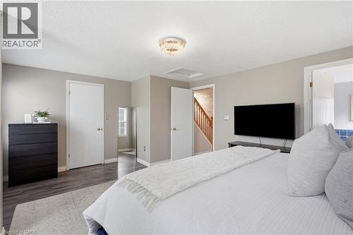 Bedroom featuring wood-finish flooring, neutral wall tones, and a contemporary ceiling fixture - 128 Houghton Street, Cambridge, ON 