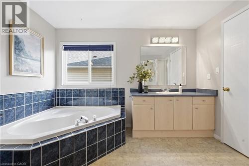 Built-in corner soaking tub featuring blue tiled surround - 128 Houghton Street, Cambridge, ON 