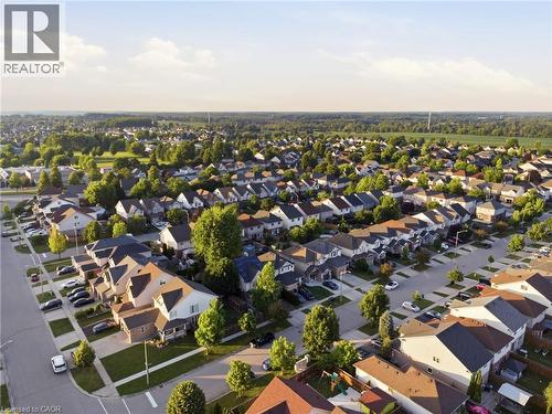 Expansive aerial perspective showcasing a residential development with numerous single-family homes and townhomes, featuring a mix of architectural styles - 128 Houghton Street, Cambridge, ON 