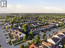 Expansive aerial perspective showcasing a residential development with numerous single-family homes and townhomes, featuring a mix of architectural styles - 