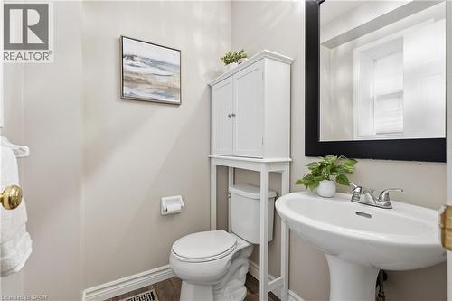Pedestal sink with chrome fixtures and a rectangular black-framed mirror - 128 Houghton Street, Cambridge, ON - Indoor Photo Showing Bathroom