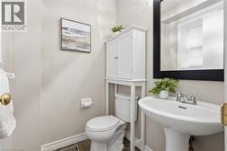 Pedestal sink with chrome fixtures and a rectangular black-framed mirror - 