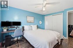 Bedroom featuring wood-finish flooring, a ceiling fan, and white bi-fold closet doors - 