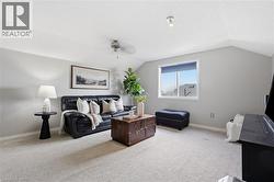 Carpeted room featuring sloped ceilings, a window with exterior views, and neutral wall paint - 