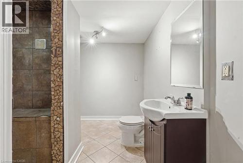 Bathroom featuring an enclosed shower with stone-look tile, mosaic tile accents, a track light fixture, a toilet, and a vanity with an integrated sink and mirror - 128 Houghton Street, Cambridge, ON - Indoor Photo Showing Bathroom