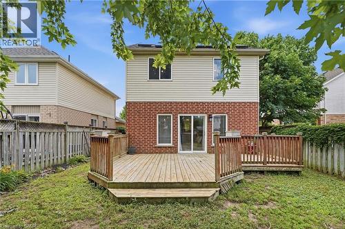 Rear exterior featuring a multi-level wood deck with railings, brick and siding facade, and mature perimeter trees - 128 Houghton Street, Cambridge, ON - Outdoor With Exterior
