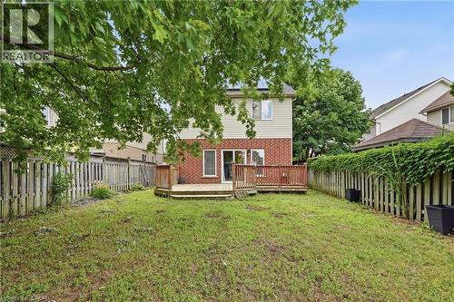 Expansive rear yard featuring a multi-level wood deck, red brick and siding exterior, and mature perimeter trees - 128 Houghton Street, Cambridge, ON - Outdoor