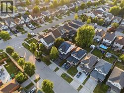 Residential neighborhood featuring detached homes with varied architectural styles, mature trees, paved streets, and sidewalks - 