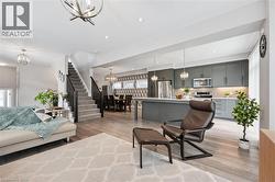 Open-concept living space featuring wood-finish flooring, recessed lighting, and contemporary light fixtures - 