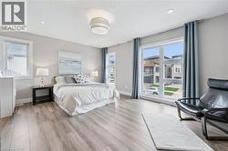Spacious room featuring wood-finish flooring, recessed ceiling lighting, and a modern ceiling fixture - 