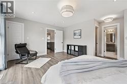 Spacious room featuring wood-finish flooring, light gray wall paint, and white trim - 