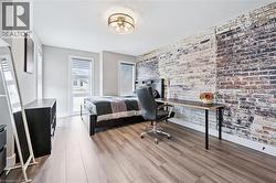 Spacious room featuring a prominent exposed brick accent wall - 