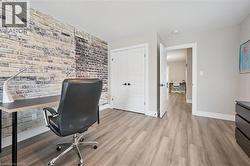 Light wood-finish flooring complements a feature wall with exposed brick-style detailing - 