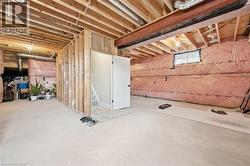 Unfinished basement featuring exposed wood joists, concrete flooring, and insulated walls - 