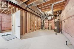 Unfinished basement space featuring exposed wood framing, concrete flooring, and visible ductwork - 