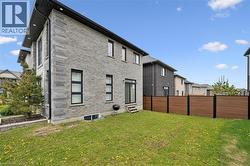 Rear exterior showcasing a two-story design with gray brick siding and dark-trimmed windows - 