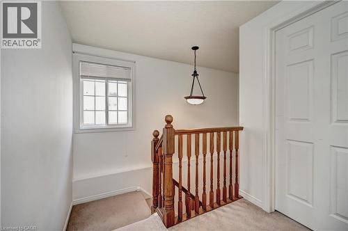 Upper level landing featuring light beige carpet, white painted walls, and a multi-pane window with blinds - 760 Paris Boulevard, Waterloo, ON 