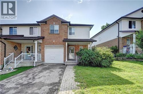 Brick and siding exterior featuring a covered front porch, an attached garage, a paved driveway, and a stone paver walkway - 760 Paris Boulevard, Waterloo, ON 
