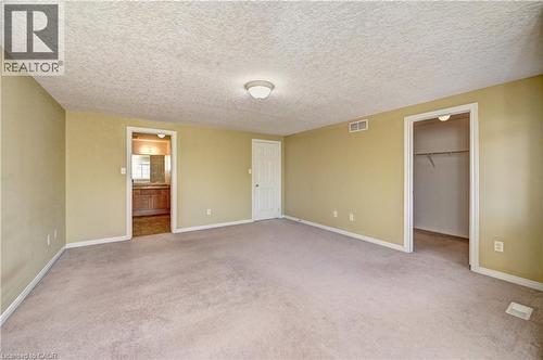 Spacious room featuring neutral carpeting, a flush mount ceiling light fixture, and a built-in closet with shelving - 760 Paris Boulevard, Waterloo, ON 