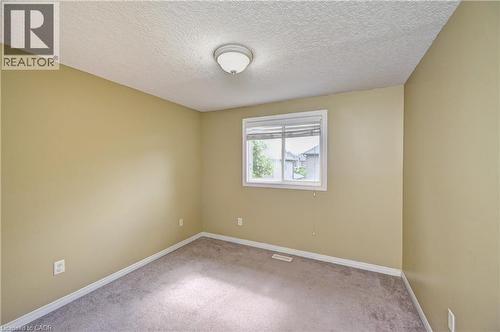 Carpeted room with a single window, a flush mount ceiling light fixture, and textured ceilings - 760 Paris Boulevard, Waterloo, ON 