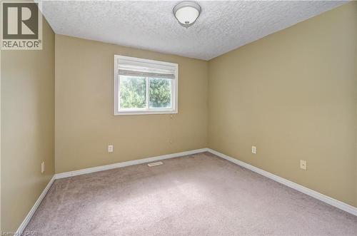 Room featuring light tan walls, a white framed window, and neutral carpet flooring - 760 Paris Boulevard, Waterloo, ON 