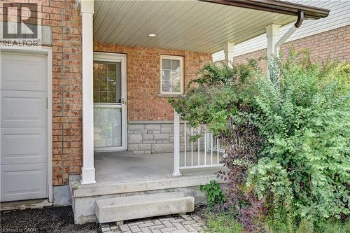 Brick facade with stone accent, covered front porch, white porch railing, and white garage door - 760 Paris Boulevard, Waterloo, ON 