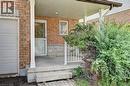 Brick facade with stone accent, covered front porch, white porch railing, and white garage door - 760 Paris Boulevard, Waterloo, ON 